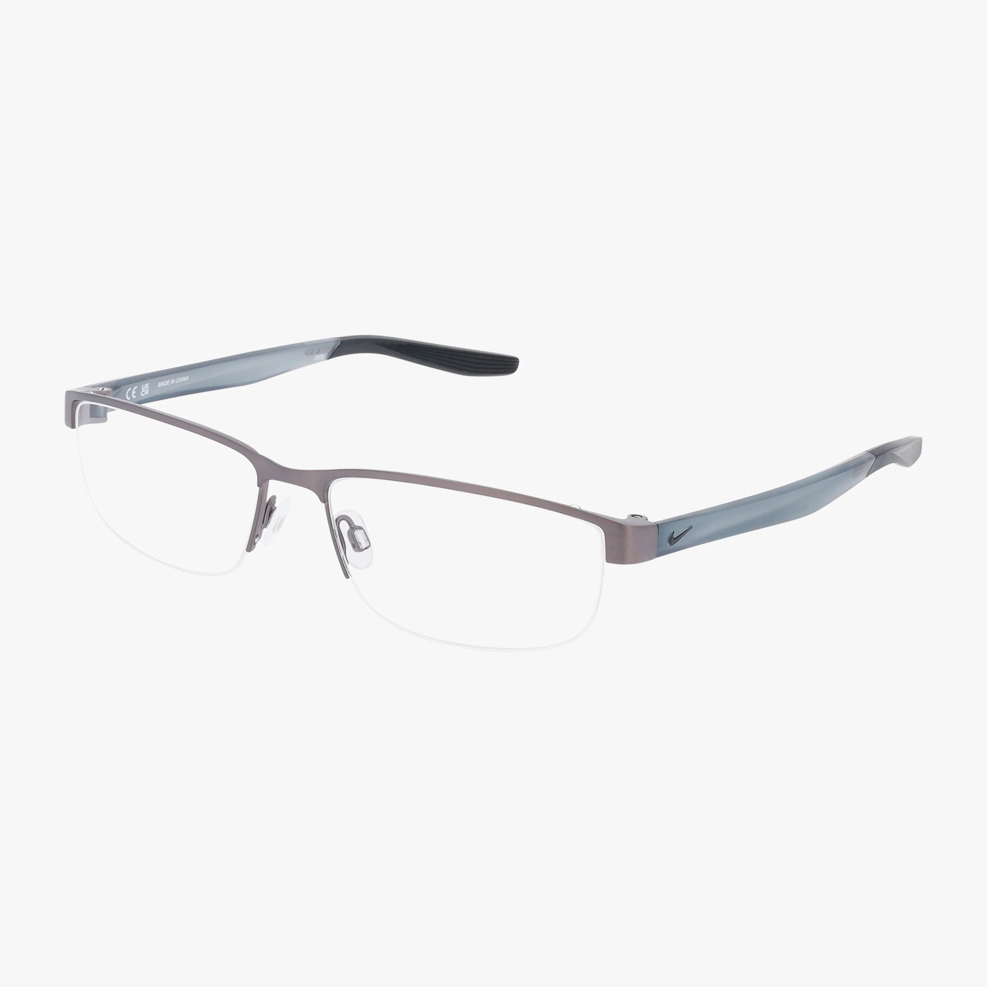 The NIKE 8138 eyeglasses feature a semi-rimless gray metal frame, clear nose pads, and black-accented temple arms with the Nike logo; this stylish frame is compatible with progressive lenses.