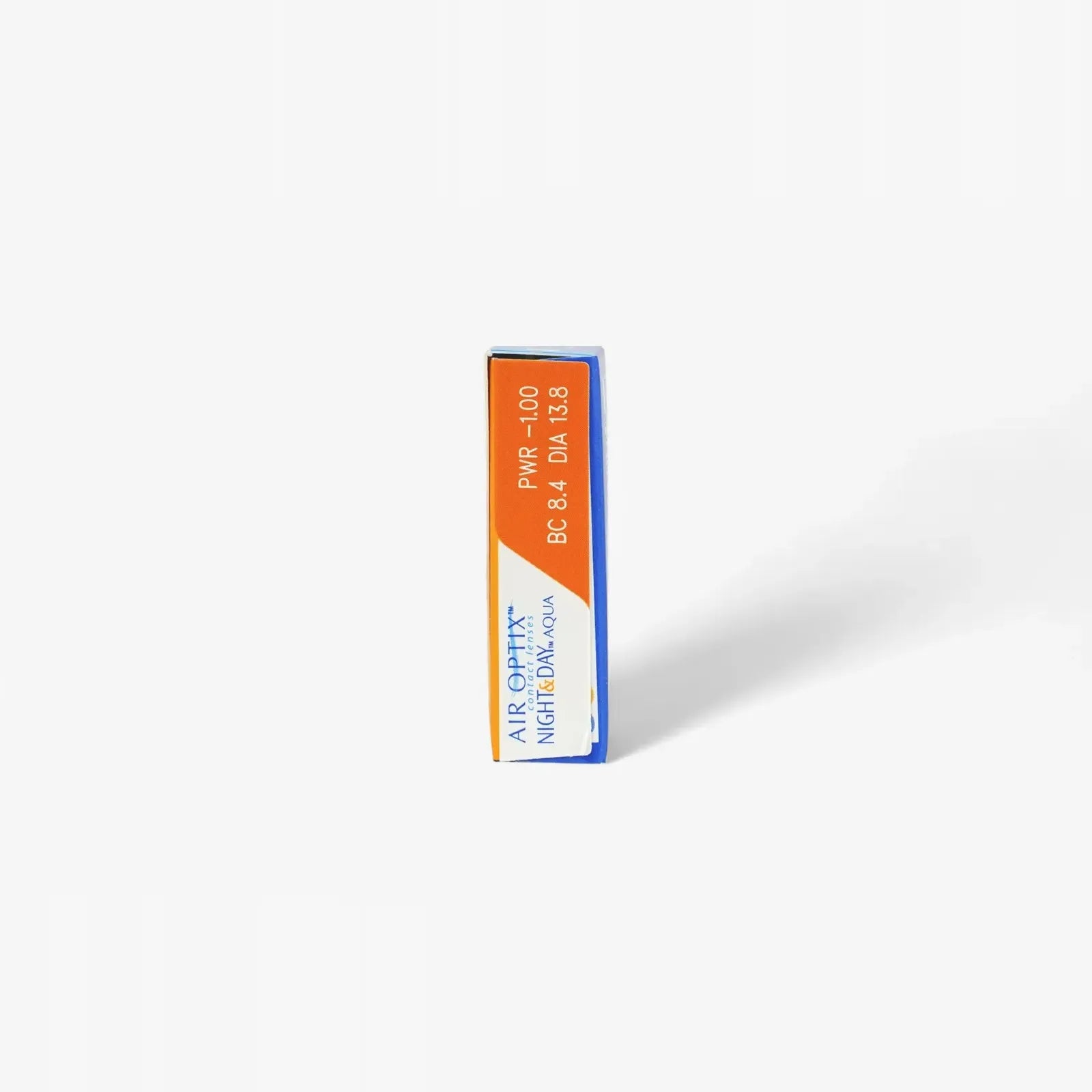 A rectangular Air Optix Night & Day - 6 Pack box stands upright on a white background, featuring orange and blue design elements with prescription info and highlighting SmartShield Technology for monthly lenses from Air Optix.