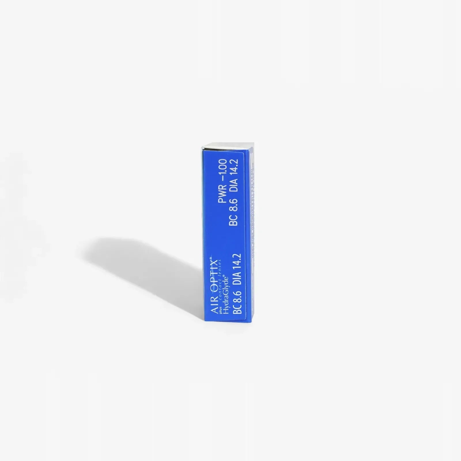 A blue rectangular box of Air Optix Plus Hydraglyde - 6Pk monthly contact lenses by Air Optix stands upright on a white background, casting a soft shadow left. Lens details are printed in white text on the visible edge of the box.