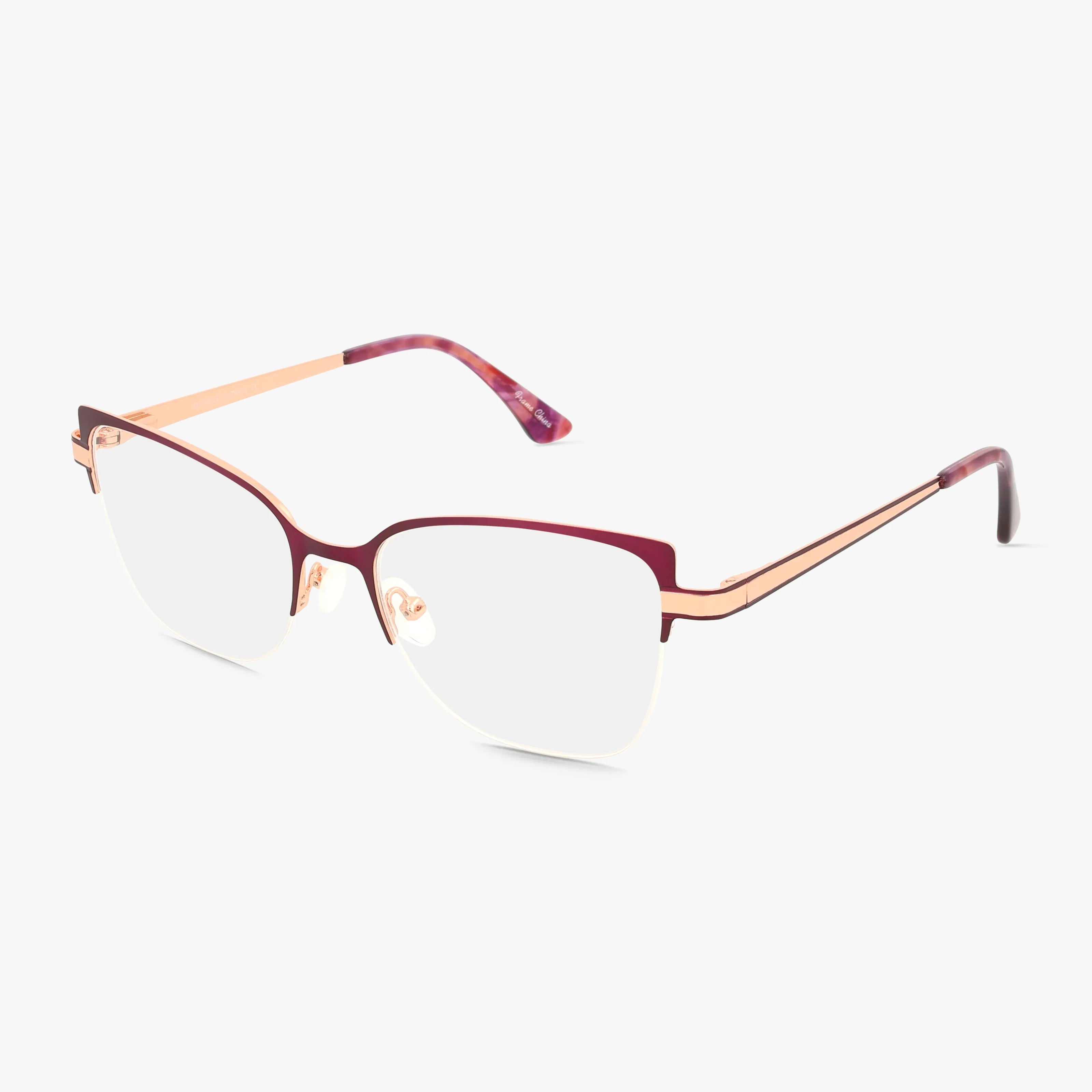 The MICHELE by St. Moritz features stylish cat-eye eyeglasses in thin purple metal, with clear lenses and adjustable nose pads—offering elegance and durability. Shown against a plain white background.