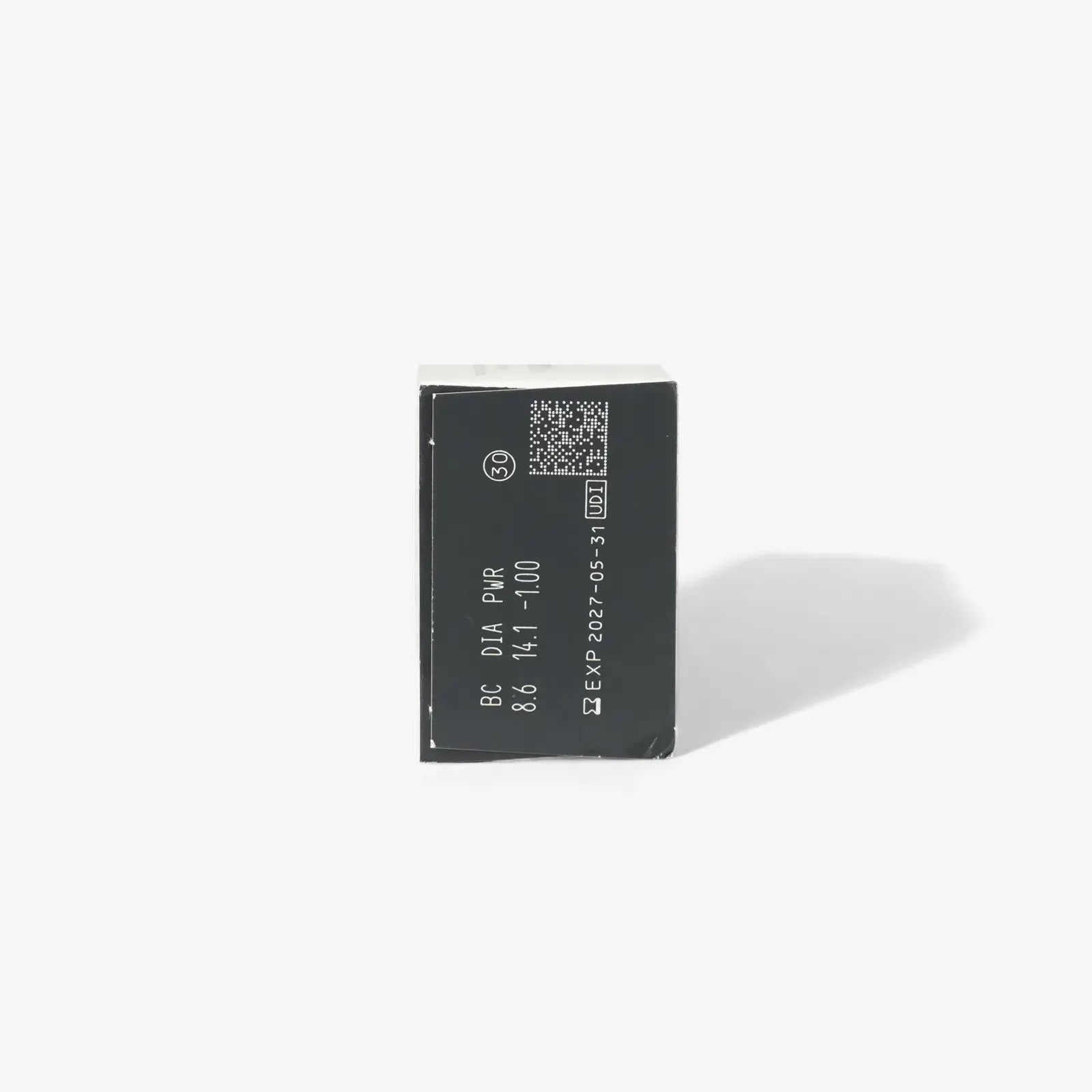A black rectangular electronic component with white text—including numbers, letters, and a 2027-05-31 expiration date—shown on a plain white background, resembling Clariti’s Clariti 1Day Sphere 30-Pk contact lens packaging.