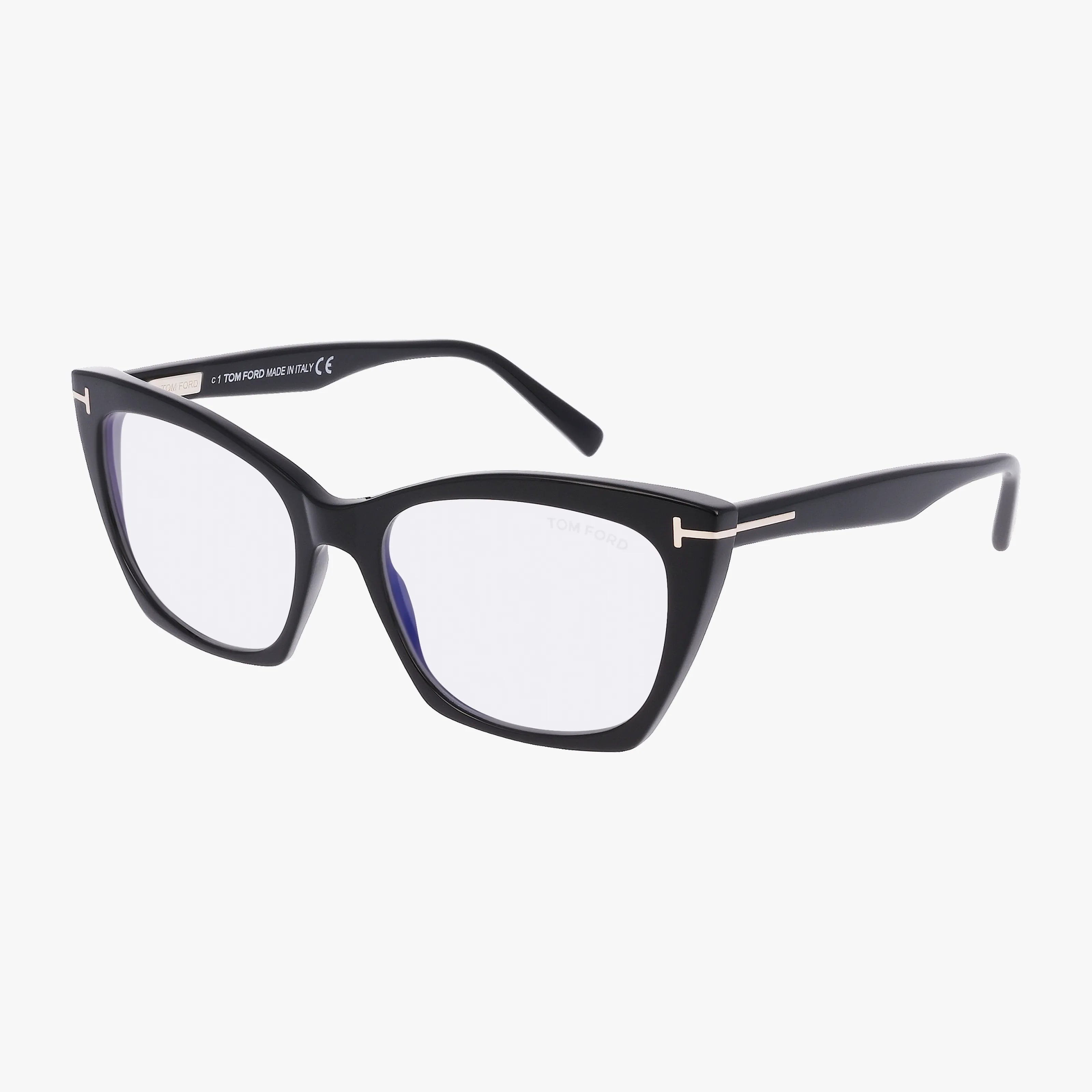 The Tom Ford FT5709-B features black cat-eye frames with clear lenses and silver detailing on the hinge and arms, offering a chic, modern look displayed against a white background.