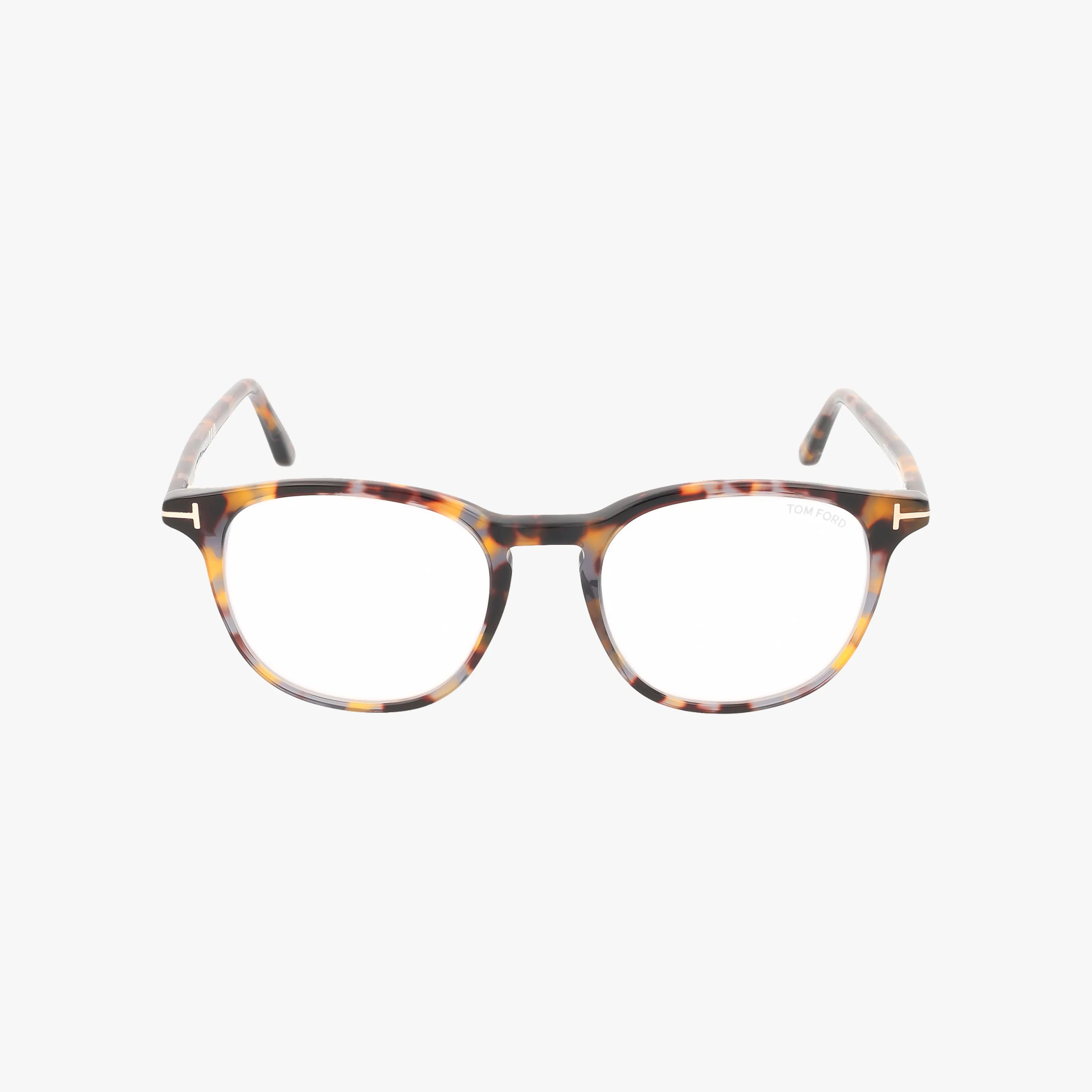 Tom Ford FT5832-B eyeglasses feature a round tortoiseshell frame with subtle T-shaped metal hinge accents, combining stylish design and durable construction. Shown on a white background.